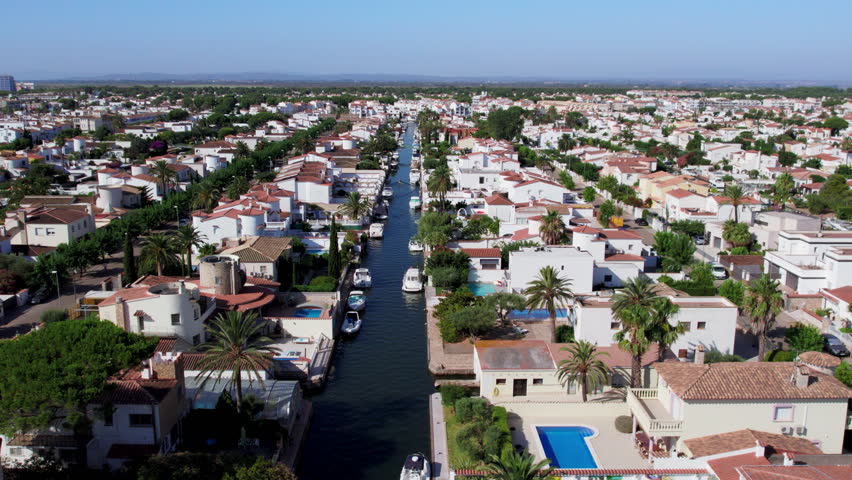 Aerial view of luxurious private community buildings in Empuriabrava. Exclusive holiday apartments or real estate for sale in Europe. Excursion on private boat. Tourist heaven destination. 