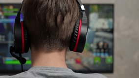 Gamer boy playing computer game. Teenage boy using headset, playing computer game. 4k
