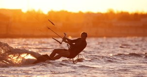 Person kitesurfing on open water extreme summer sport, slow motion. Person goes kitesurfing at sunset extreme active sport. Summer fun happiness in unity with nature, template for title cinematic AD 