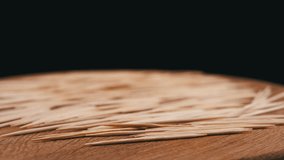 Lots of Scattered Brown Toothpicks Rotate on a Wooden Background. Black background. Texture of sharp bamboo wooden toothpicks. Home oral care after meals. Teeth cleaning. Blurred motion. Dentistry. - Powered by Shutterstock - Get 15% off with code: PIKWIZARD15