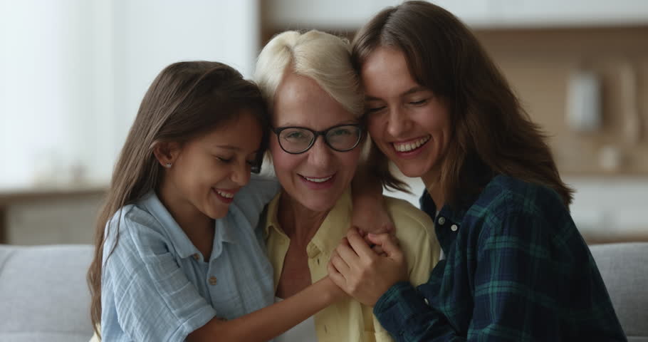 Cheerful cute girl and young mom hugging happy beloved senior grandma with love, care, affection, enjoying family generations meeting, leisure time together, close relationship Royalty-Free Stock Footage #3425601931
