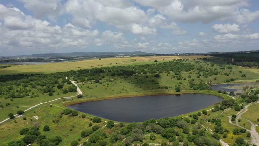 An aerial view of a water Reservoir surrounded by green fields