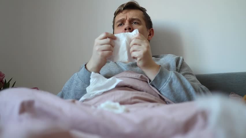 Close-up portrait of sick young man sneezing. sick and illness concept using napkins Royalty-Free Stock Footage #3425660599