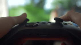 Close-up of Gamer Hands Playing Video Game on Console Using Joystick. Child Playing on Black Controller in Computer Video Game. Hands Person Playing Video Games on Console With Gamepad at Home.