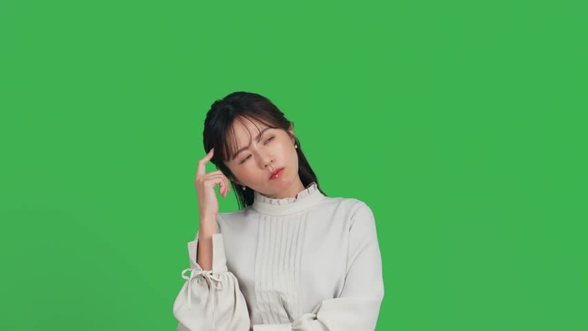 Worried middle-aged Asian woman. Green background for chroma key composition. Royalty-Free Stock Footage #3425704787