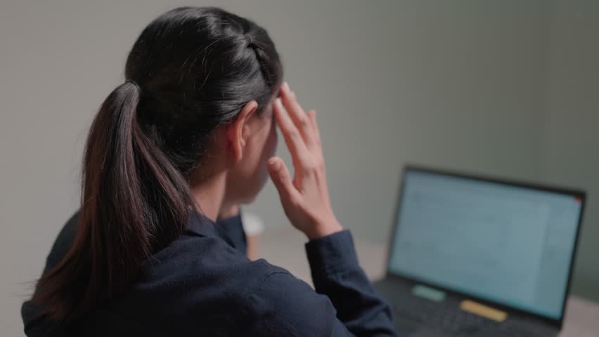 Woman reads bad news on laptop computer while sitting at work and is disappointed with notifications she receives news Royalty-Free Stock Footage #3425737325