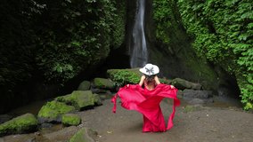 4k slow motion video.Young female tourist tourist on the background of Leke Leke waterfall in Bali island, Indonesia.