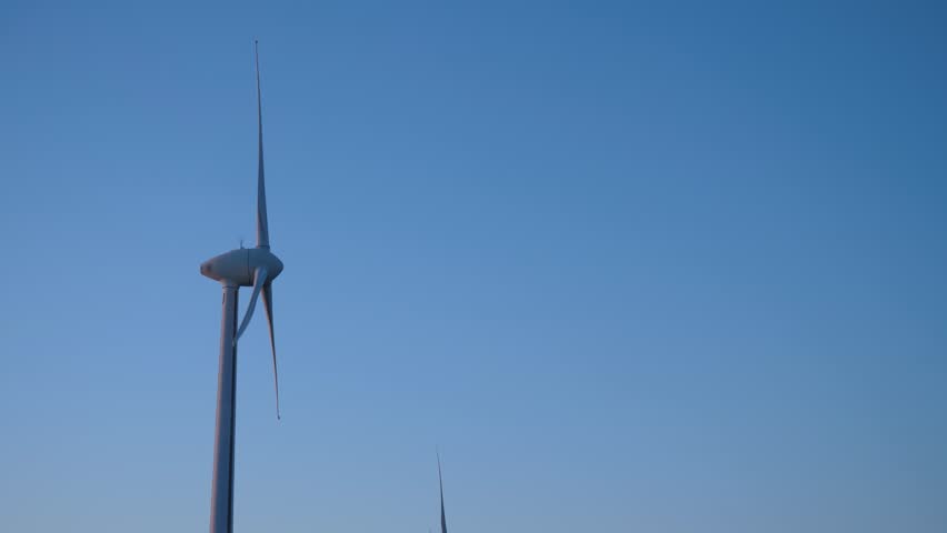 Green energy production, copy space. Wind mill turbines park with blue sky, windmill park, side view Royalty-Free Stock Footage #3425900627
