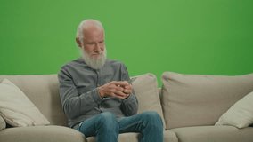 Green Screen. A Rich Old Man with a Gray Beard Counting His Money in US Dollars. An Elderly Man is Satisfied by the Amount of US Dollar Money in His Hands. Retirement Income.