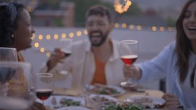 Gathering of cheerful young friends toasting with red wine and celebrating party on terrace of house. People together drinking alcoholic beverages outdoor. Boys and girls enjoying free time on weekend - Powered by Shutterstock - Get 15% off with code: PIKWIZARD15