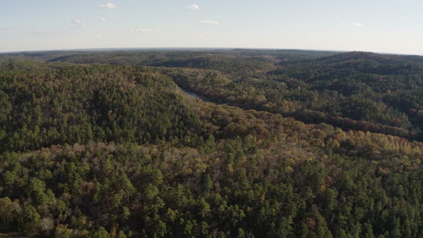 Aerial view of southeastern Oklahoma fall foliage landscape with Mountain Fork River near Broken Bow Lake and Hochatown during golden hour sunset - 4K Drone