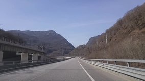 Cars on road to Sochi among mountains at sunny day, shooting from moving car, mobile phone video.