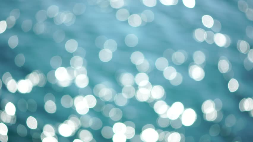 Abstract sea summer ocean sunset nature background. Small waves on golden water surface in motion blur with golden bokeh lights from sun. Holiday, vacation and recreation. Weather and climate change.