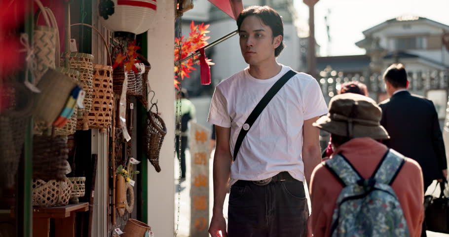 Walking, shopping and Japanese man in the city exploring on a summer vacation, adventure or holiday. Travel, sightseeing and young male person commuting in street in Yokohama town on weekend trip.