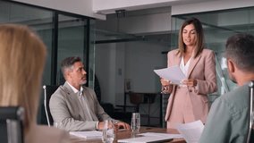 Busy business team people having corporate business discussion at group meeting. Smiling female executive mature Latin manager working with board company members discussing project at office table. - Powered by Shutterstock - Get 15% off with code: PIKWIZARD15