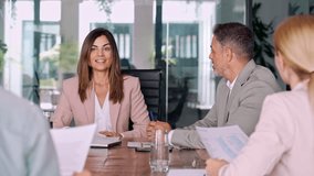 Busy business people having corporate business discussion at group meeting. Female executive mature Latin manager CEO leading team working together discussing project at office table. - Powered by Shutterstock - Get 15% off with code: PIKWIZARD15