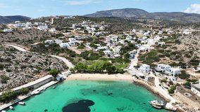 Aerial drone video of paradise sandy beach of Agios Georgios with natural tree shade next to main port of Iraklia island, Small Cyclades islands, Greece