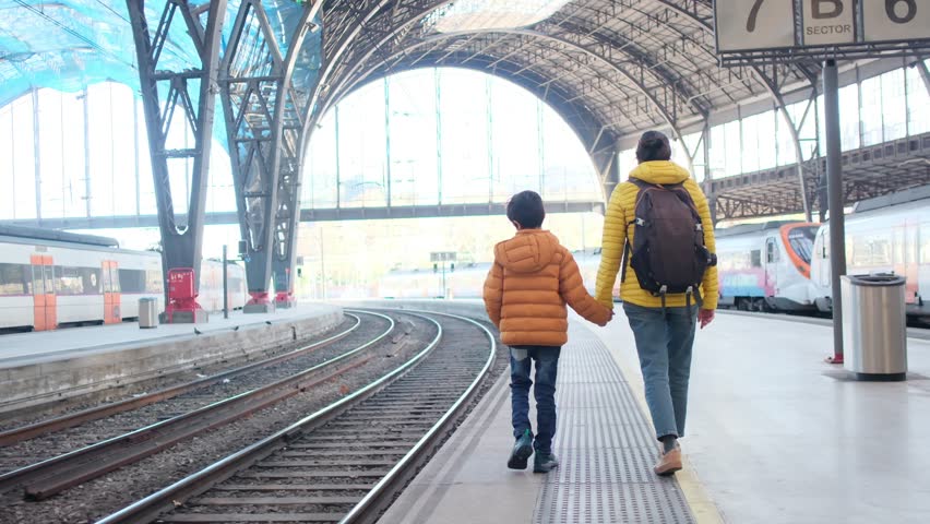 Mother with son, single mother walking through the park, Barcelona train station, visiting the city, travel concept, single parent mother with son, adventure of discovering the city and the world