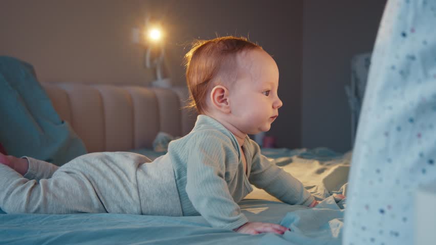A curious child, positioned on its stomach, exhibits the developmental milestone. With eyes full of wonder and a soft smile, the child engaged with the environment.