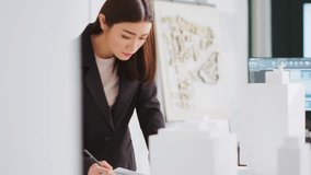 Designer drawing lines on architectural blueprints in office, working on creating a floor plan for the new building. Asian architect examining 3d printed model on table, translating measurements. - Powered by Shutterstock - Get 15% off with code: PIKWIZARD15