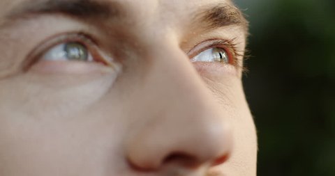 Close up of the caucasian man's face and eyes looking up to the sky with a hope. Portrait Arkivvideo