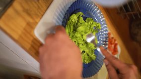 Man mashing avocado with fork on a plate to prepare a healthy toast in Chile.