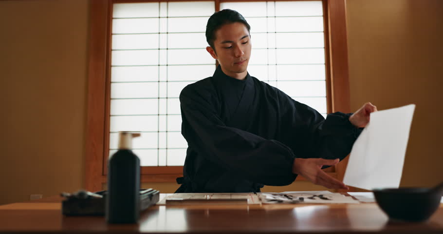 Paper, ink and traditional Japanese man for writing letters, notes and text for documents or script. Creative writer, culture and person with paint, tools and desk for calligraphy and handwriting
