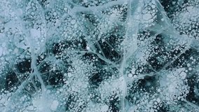 Aerial drone view frozen methane bubbles and cracks in the ice on Lake Baikal Siberia Russia. Natural cold background of ice. Winter abstract background. High quality 4k footage - Powered by Shutterstock - Get 15% off with code: PIKWIZARD15