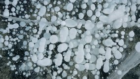Aerial drone view frozen methane bubbles and cracks in the ice on Lake Baikal Siberia Russia. Natural cold background of ice. Winter abstract background. High quality 4k footage - Powered by Shutterstock - Get 15% off with code: PIKWIZARD15