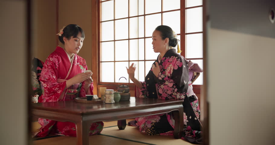 Women, Japanese and tea ceremony in traditional tatami room for healing ritual, harmony or calm environment. Female people, kimono dress and hot drink for connection, religious experience or health Royalty-Free Stock Footage #3426703069