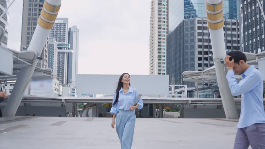 Asian young business people say hi and doing high five outdoor in city. Attractive team of employee man and woman worker greeting each other while met each other and standing outside the office. Royalty-Free Stock Footage #3426704869