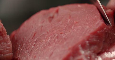 the chef cut raw meat beef fillet, makes the preparation for cooking, Dolly shot, close-up