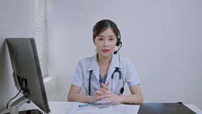 Therapy consulting,telemedicine concept.Asian woman doctor talking online with patient,video online,telemedicine,looking at camera,making video call.young female wearing white uniform with stethoscope