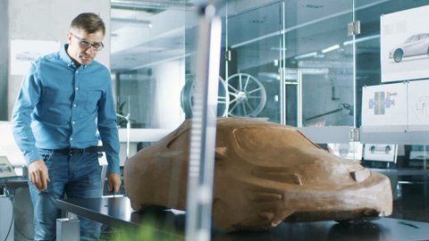 Experience Automotive Designer with a Rake Sculpts Prototype Car Model from Plasticine Clay. He Works in a Modern Studio in a Major Automotive Company's Headquarters. Shot on RED EPIC-W 8K Camera.