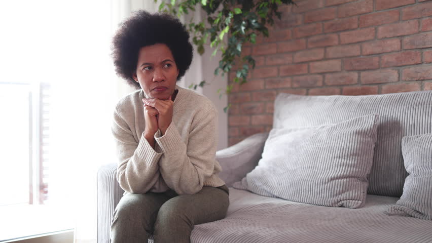African American woman sitting at home, feeling miserable and depressed Royalty-Free Stock Footage #3426860781