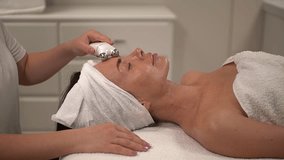 woman receives massage.microcurrents for face.woman in spa. Slow motion video. High quality video in 4K format.