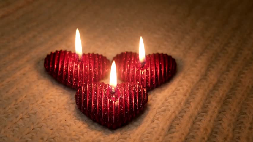 Velas románticas decoradas con corazones y un regalo con un fondo  desenfocado