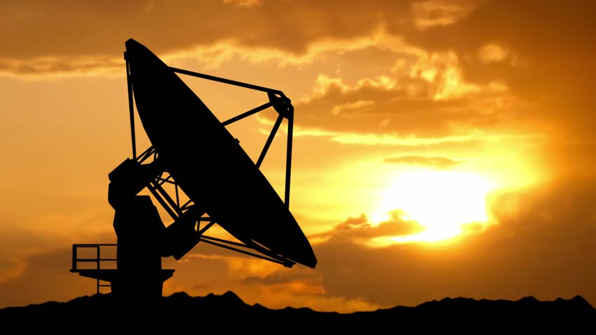 Black silhouette of big radar antenna outdoors over sunset sky. One big modern satellite station dish telescope moving and rotating up.