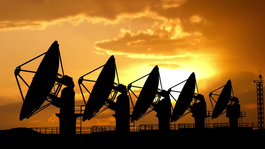Black silhouette of big radar telescope outdoors over sunset sky. Row of modern satellite station dish telescope moving and rotating.