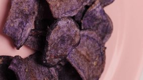 purple sweet potato chips, rotation in circle. Fried purple chips from the barracks (fast food), Turning. selective focus. vegetable chips. Vertical video
