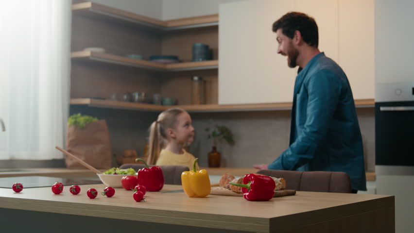 Caucasian family single dad father lift child in his arms up rise little kid daughter spinning rotate touch with noses love affectionate at kitchen home after cooking food cook salad bonding childcare Royalty-Free Stock Footage #3427106049