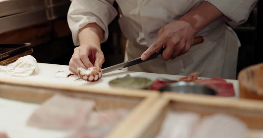 Cooking, hands and sushi chef knife in a restaurant with catering, fish chop and Japanese dish in kitchen. Menu, culinary artist and fine dining with tuna and person with food and sashimi for dinner