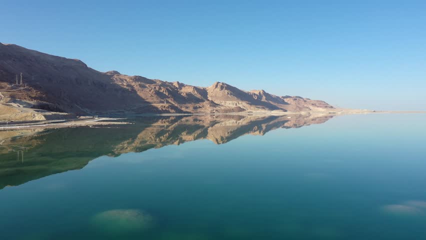 An aerial view of mountains reflecting in the waters of the dead sea