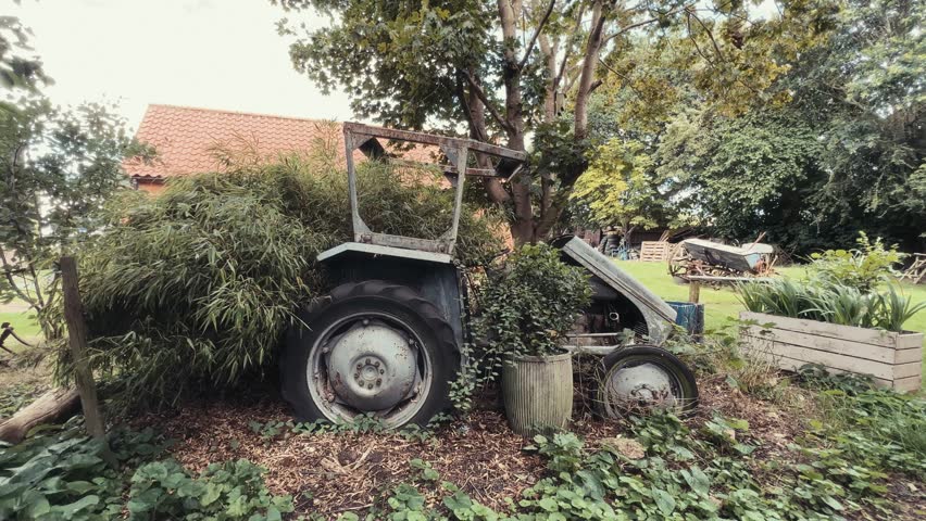 Old vintage historical farm machinery equipment sitting around in a farmers field. Retro 70s movie effects
