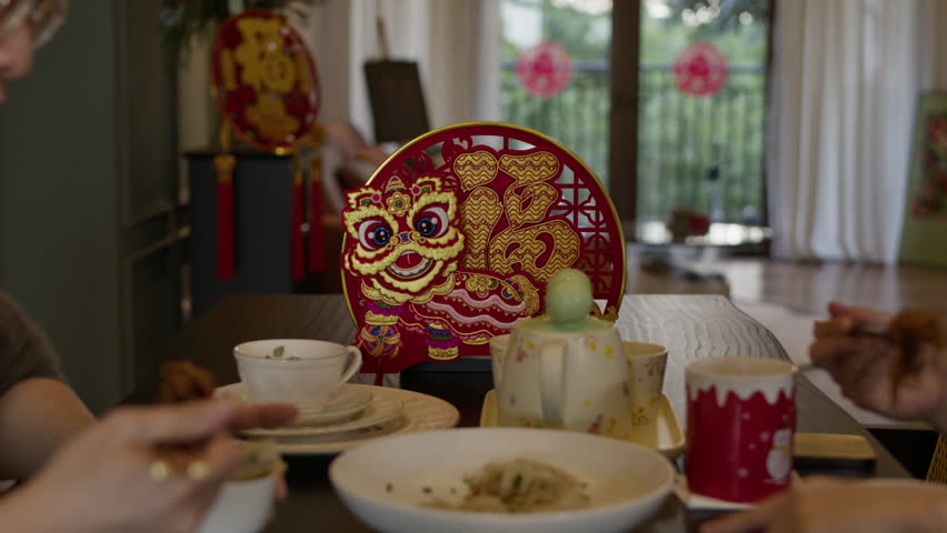 Chinese New Year celebration , married couple having a meal together eating noodles, celebration holiday in modern house with traditional decoration Royalty-Free Stock Footage #3427300043