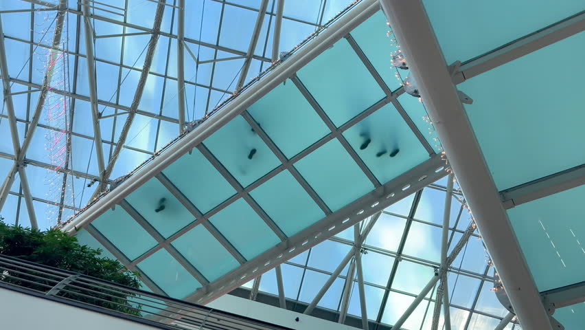Beautiful futuristic modern glass building and people walking on glass suspension bridge. Bottom view of the footprints of people on the glass bridge Royalty-Free Stock Footage #3427396473