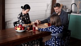 Happy family holding hands and praying with closed eyes before having a meal. Caucasian christians parents with small daughter arms together thanksgiving to god on dining table - Powered by Shutterstock - Get 15% off with code: PIKWIZARD15