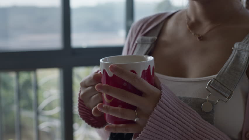 close up of beautiful chinese oriental young girl woman drinking. a cup of coffee at home