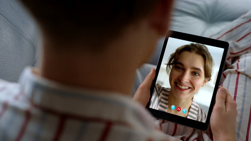 Closeup girl speaking web camera with guy. Distant happy couple talking online using communication app at home. Unrecognized man chatting wife in tablet. Smiling woman calling partner shoulder view Royalty-Free Stock Footage #3427435631