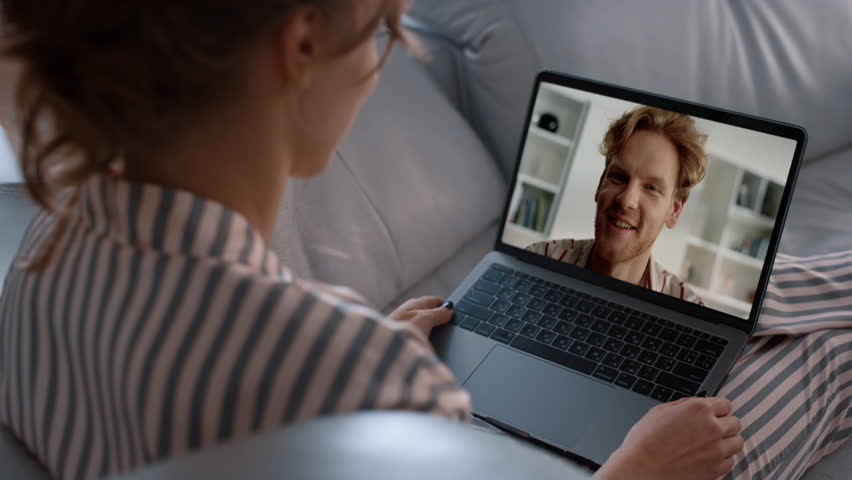 Smiling man videocalling woman in laptop screen at home closeup. Young couple talk remotely enjoying videochat. Unrecognized woman resting couch speaking partner online. Family relationship lifestyle. Royalty-Free Stock Footage #3427446109